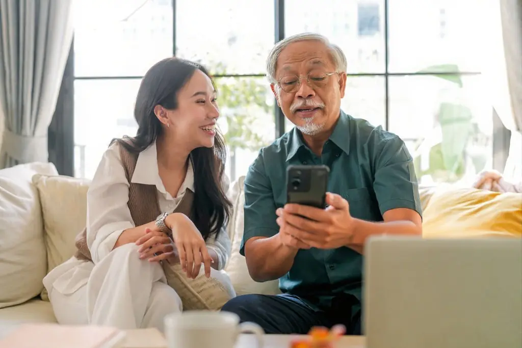 Asian elderly woman renewing her Canadian Dental Care Plan coverage on a laptop