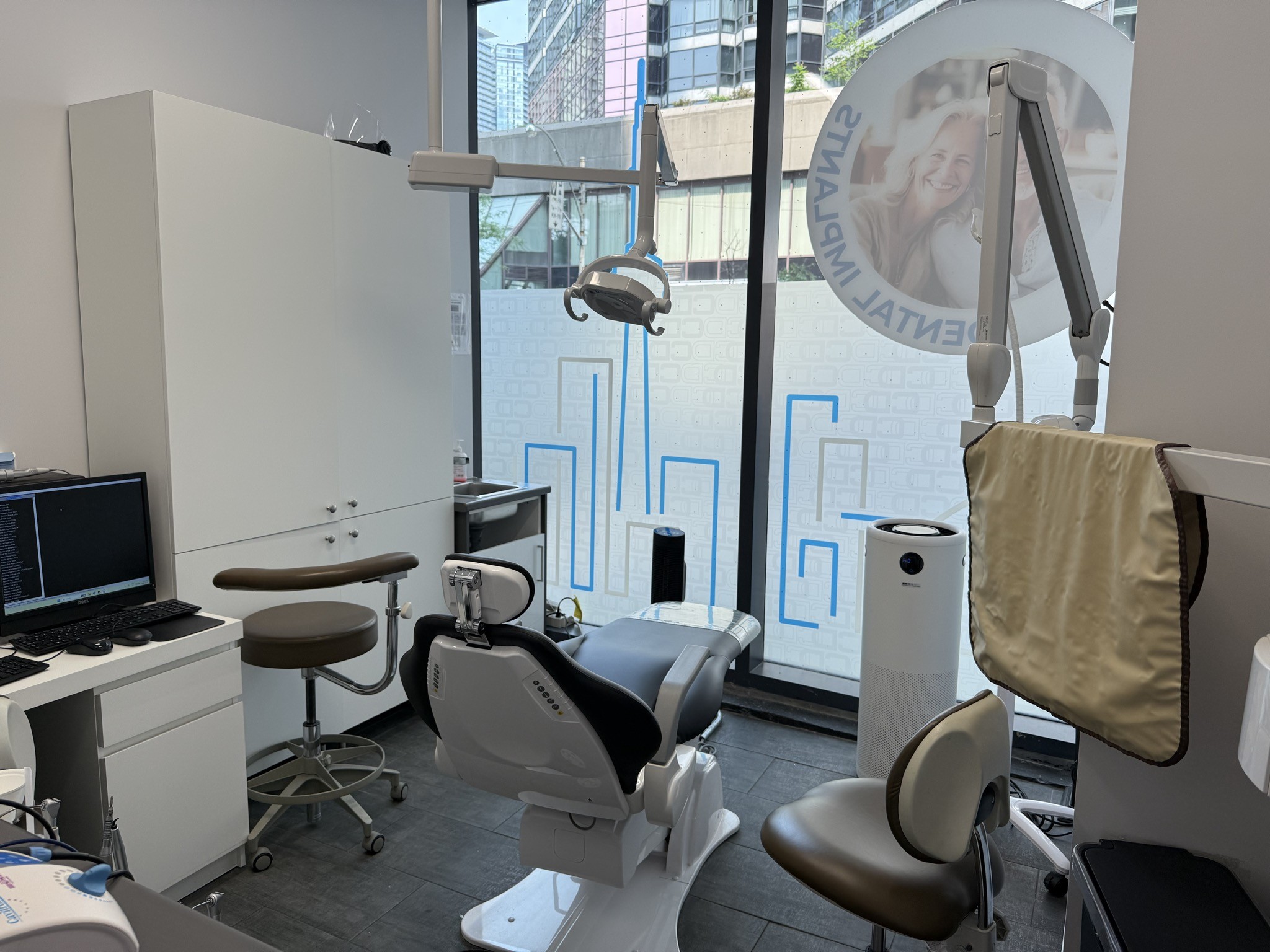 Modern emergency dental operatory at Lok Dentistry with digital X-ray and downtown Toronto view, 1006 Bay Street